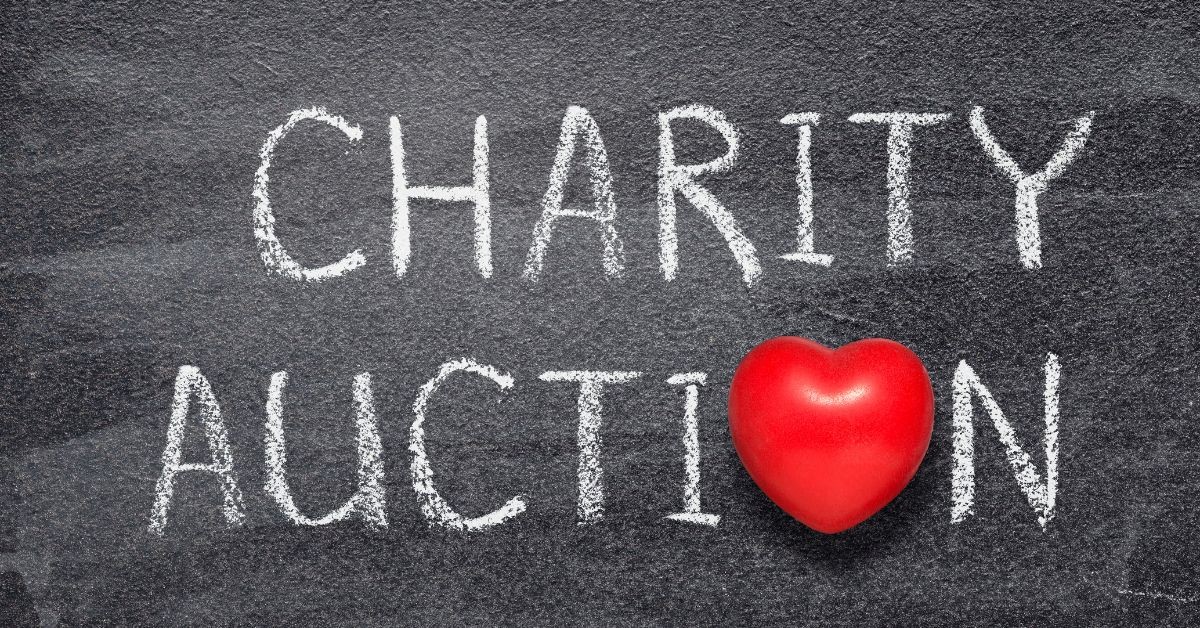 Chalkboard reading Charity Auction with a red heart accent