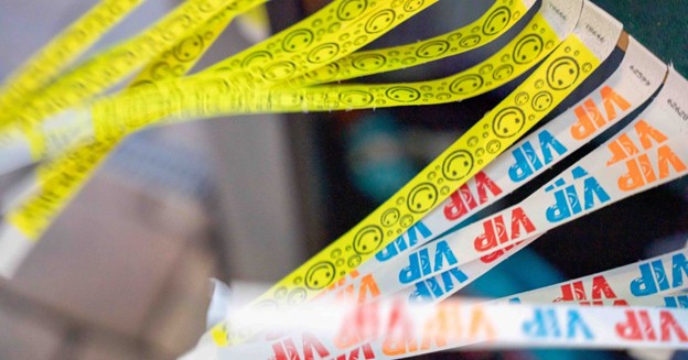 Assorted printed Tyvek VIP wristbands fanned out on a counter