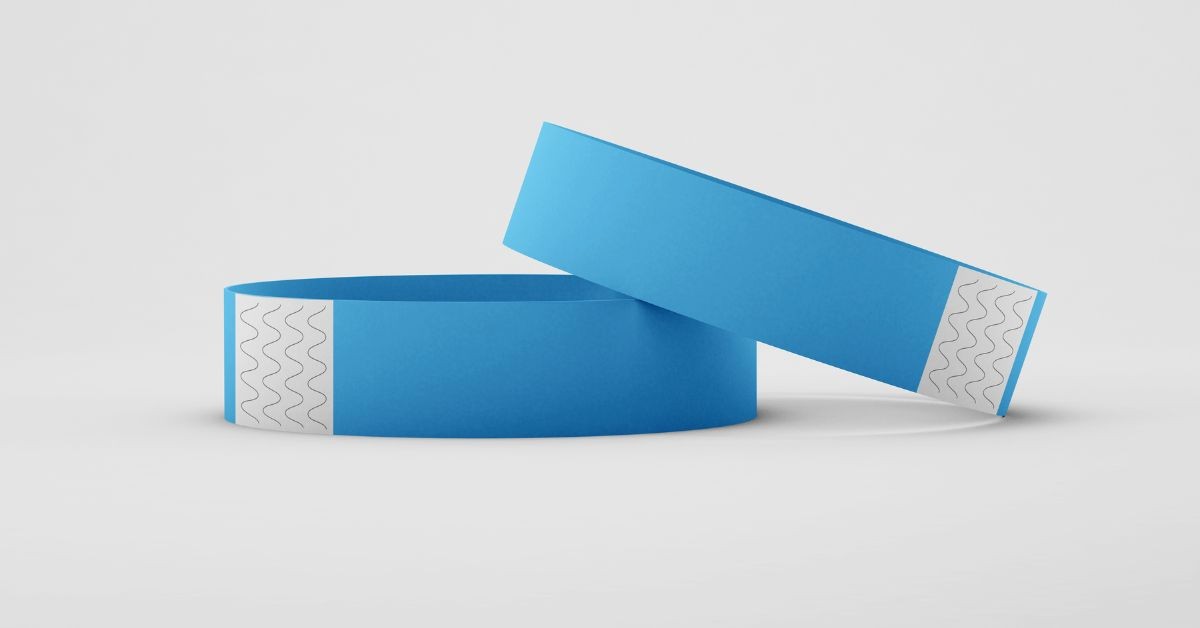 Pair of blue Tyvek paper event wristbands with tamper-evident adhesive patches
