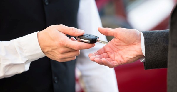 Valet attendant handing a car key to a guest