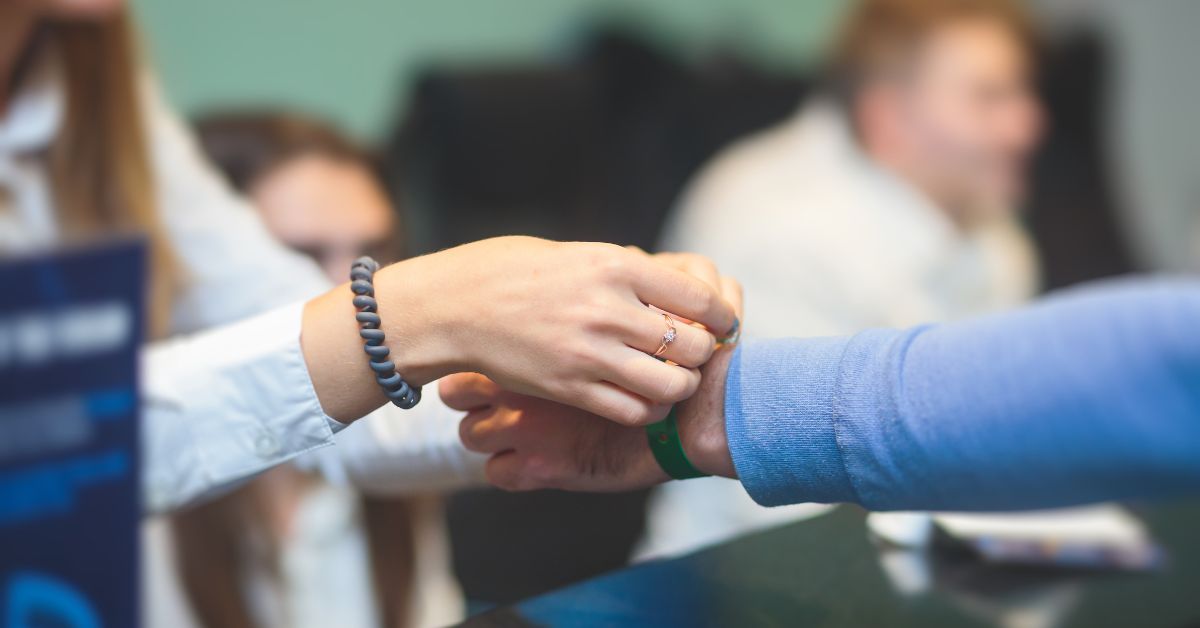 Event staff applying a green wristband at the check-in counter